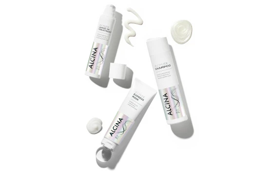 Drei Alcina-Produkte Maske Shampoo Treatment auf weißer Oberfläche