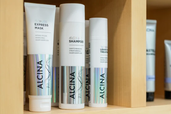Drei Alcina-Produkte Maske Shampoo Treatment auf weißer Oberfläche