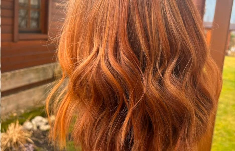 Wellenlanges rotes Haar mit Goldtönen bokeh-ähnliche Hintergrundbeleuchtung